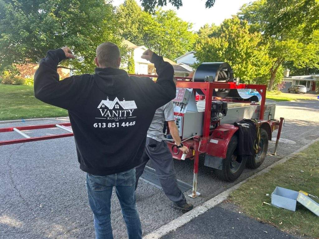 Vanity Roofing team next to their custom metal roofing machine